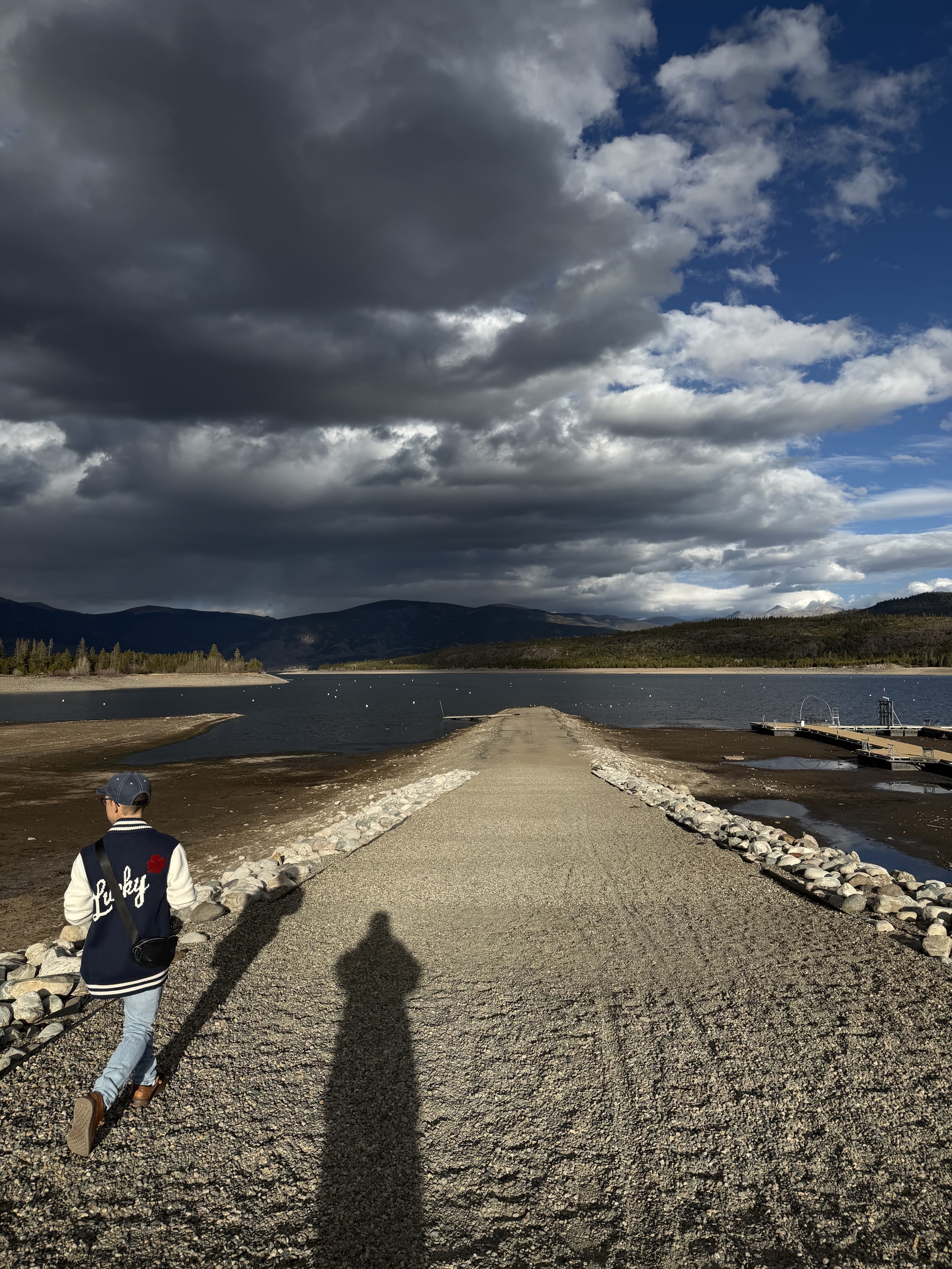 Walking along the jetty at the Frisco Marina beneath dramatic clouds over Lake Dillon
