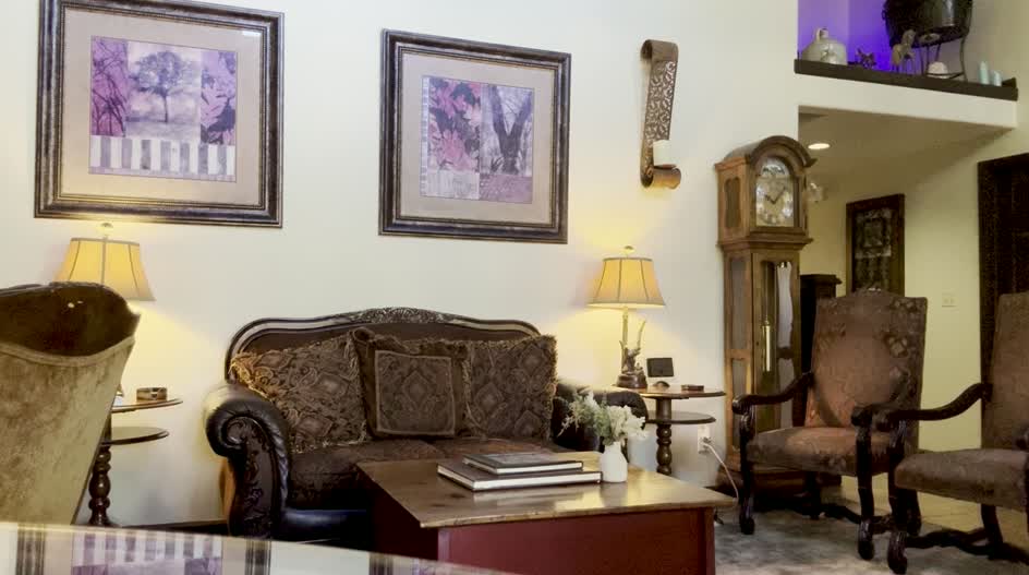 The parlor with the lamps on, books waiting on the table.