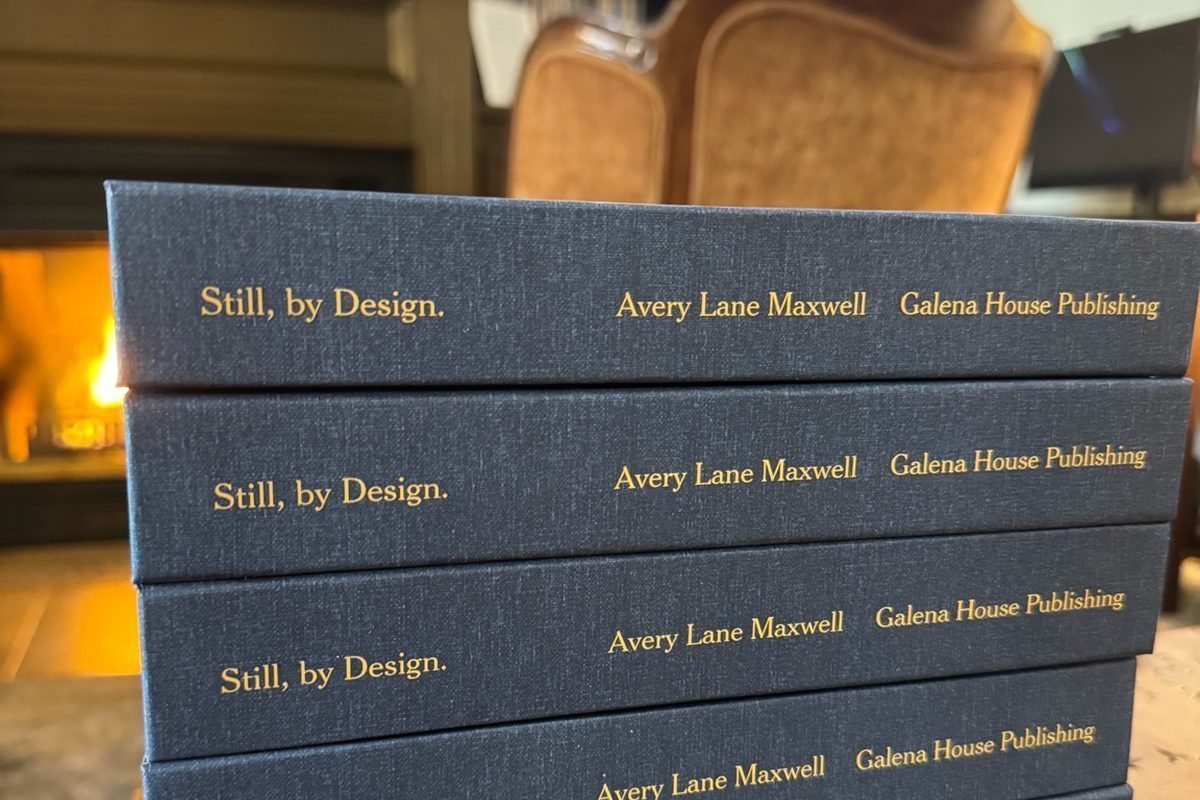 Hardcovers of Still, by Design. stacked beside a fire.
